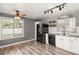 Charming kitchen featuring white cabinets, stainless steel appliances, and wood-look floors at 2802 Secret Canyon Rd, Las Vegas, NV 89074