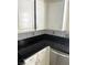 Features white cabinets, black countertop, and mosaic tile backsplash at 3436 Pino Cir, Las Vegas, NV 89121