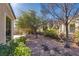 Expansive backyard featuring desert landscaping, mature trees, and a tranquil water feature at 4705 Bersaglio St, Las Vegas, NV 89135