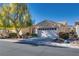 Inviting home featuring a two-car garage, manicured landscaping, and mature trees in the front yard at 4705 Bersaglio St, Las Vegas, NV 89135