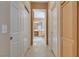 Hallway view to bathroom showcasing tiled floors, neutral paint and multiple door access at 4705 Bersaglio St, Las Vegas, NV 89135
