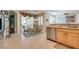 Open kitchen with stainless steel dishwasher and a view into the dining area with outside patio access at 4705 Bersaglio St, Las Vegas, NV 89135
