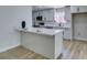 Modern kitchen featuring grey cabinets, stainless steel appliances, and a breakfast bar with white countertop at 5800 Balzar Ave, Las Vegas, NV 89108