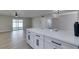 Open living space with light tile floors and slider to backyard, visible from the kitchen's quartz countertop bar at 5800 Balzar Ave, Las Vegas, NV 89108