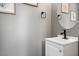 Neutral bathroom features a modern sink, framed artwork and a round mirror at 5945 Sunlight Garden Way, Las Vegas, NV 89118