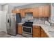 Well-equipped kitchen with stainless steel appliances, granite countertops, and wooden cabinetry at 5945 Sunlight Garden Way, Las Vegas, NV 89118