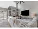 Bright living room features a gray plush sofa, fireplace, and large windows with plantation shutters at 5945 Sunlight Garden Way, Las Vegas, NV 89118
