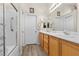 Clean bathroom features a shower, double vanity, oak cabinets, and modern fixtures at 6611 Cinnabar Coast Ln, North Las Vegas, NV 89084