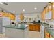 Eat-in kitchen features an island, oak cabinets, white appliances, and tile floors at 6611 Cinnabar Coast Ln, North Las Vegas, NV 89084