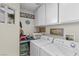 Well-organized laundry room with modern appliances, ample storage cabinets, and an efficient layout at 6611 Cinnabar Coast Ln, North Las Vegas, NV 89084