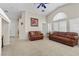 Cozy living area with tile flooring, comfortable leather sofas, and a ceiling fan at 6611 Cinnabar Coast Ln, North Las Vegas, NV 89084