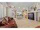 Open-concept living room with tile floors, a leather sofa, and a view into the adjacent kitchen at 6611 Cinnabar Coast Ln, North Las Vegas, NV 89084