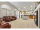 Bright living room with tile floors, leather sofas, and ample natural light from the large windows at 6611 Cinnabar Coast Ln, North Las Vegas, NV 89084