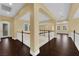 Spacious hallway with dark wood floors, white railings, and large columns, creating an open and inviting atmosphere at 7293 Iron Oak Ave, Las Vegas, NV 89113