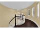 Elegant curved hallway showcasing dark wood floors and a stylish white railing, bathed in natural light from large windows at 7293 Iron Oak Ave, Las Vegas, NV 89113