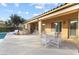 Outdoor dining area with white table and chairs alongside the covered patio and outdoor grill at 7307 Iron Oak Ave, Las Vegas, NV 89113