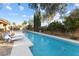 Refreshing backyard pool and patio with mature trees, and lounge chairs at 7307 Iron Oak Ave, Las Vegas, NV 89113