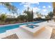 Sparkling backyard pool and spa with a well-manicured landscape under a bright, sunny sky at 7307 Iron Oak Ave, Las Vegas, NV 89113