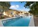 Serene backyard featuring a pool with a covered patio area, lounge chairs and a grill at 7307 Iron Oak Ave, Las Vegas, NV 89113
