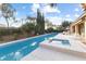 Beautiful backyard pool and spa surrounded by lush landscaping and a comfortable patio area at 7307 Iron Oak Ave, Las Vegas, NV 89113