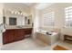 Luxurious bathroom with a soaking tub, dual vanities, and elegant tile work at 7307 Iron Oak Ave, Las Vegas, NV 89113