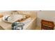 Close-up of a luxurious bathtub with decorative accents and a wooden stool for convenience at 7307 Iron Oak Ave, Las Vegas, NV 89113