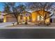 Inviting single-story home with stone accents, warm lighting, and landscaped front yard at dusk at 7307 Iron Oak Ave, Las Vegas, NV 89113