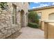 Stone accent wall entryway with lush landscaping on a tan home at 7307 Iron Oak Ave, Las Vegas, NV 89113