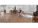 Open-concept living room with wood floors, white walls, and a dining area at 7307 Iron Oak Ave, Las Vegas, NV 89113