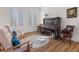 Bright living room with wood floors, white walls, a sitting area and a decorative rug at 7307 Iron Oak Ave, Las Vegas, NV 89113