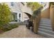 Tranquil outdoor patio featuring a stone fireplace, verdant foliage, and stairs to upper yard at 7307 Iron Oak Ave, Las Vegas, NV 89113