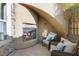 Cozy patio area with a stone fireplace and comfortable seating for outdoor relaxation at 7307 Iron Oak Ave, Las Vegas, NV 89113