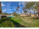 Expansive backyard featuring a sparkling pool, lush green lawn, and mature landscaping for ultimate outdoor enjoyment at 8880 W La Mancha Ave, Las Vegas, NV 89149