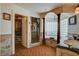 Luxurious bathroom featuring a walk-in shower and a soaking tub with decorative columns at 8880 W La Mancha Ave, Las Vegas, NV 89149