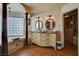 Bathroom featuring dual sinks, a tub, and access to the walk-in closet at 8880 W La Mancha Ave, Las Vegas, NV 89149