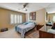 Cozy bedroom featuring a ceiling fan, window shutters, a rug, and warm-toned walls at 8880 W La Mancha Ave, Las Vegas, NV 89149