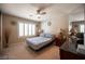 Bright bedroom with a queen bed, a ceiling fan, a window with shutters, and dark wood accents at 8880 W La Mancha Ave, Las Vegas, NV 89149