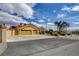 Spacious three-car garage with yellow doors and desert landscaping at 8880 W La Mancha Ave, Las Vegas, NV 89149