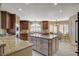 Bright kitchen with granite counters, center island, wood cabinets, stainless appliances, and breakfast nook at 8880 W La Mancha Ave, Las Vegas, NV 89149
