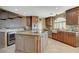 Kitchen features an island, stainless appliances, modern fixtures, and tile floors at 8880 W La Mancha Ave, Las Vegas, NV 89149