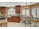 Eat-in kitchen featuring granite countertops, farmhouse sink, and stainless steel appliances at 8880 W La Mancha Ave, Las Vegas, NV 89149