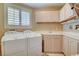 Functional laundry room with washer, dryer, utility sink, cabinets, and window at 8880 W La Mancha Ave, Las Vegas, NV 89149