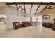 Open living space with exposed beam ceiling, tile floors, and seamless flow into the kitchen at 8880 W La Mancha Ave, Las Vegas, NV 89149