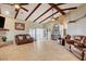 Spacious living room with beamed ceilings, tile flooring, and abundant natural light at 8880 W La Mancha Ave, Las Vegas, NV 89149