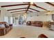 Expansive living room featuring beamed ceilings, tile floors, and abundant seating for guests at 8880 W La Mancha Ave, Las Vegas, NV 89149