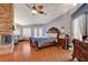 Main bedroom with stone fireplace, accent walls, hardwood floor, and double French doors at 8880 W La Mancha Ave, Las Vegas, NV 89149
