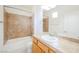 Bathroom featuring tub with tile surround, a sink with natural toned countertop, and plenty of natural light at 9050 W Tropicana Ave # 1178, Las Vegas, NV 89147