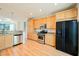 Bright kitchen with wooden cabinets, stainless steel appliances, and durable hardwood flooring at 9050 W Tropicana Ave # 1178, Las Vegas, NV 89147