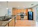 Well-lit kitchen featuring wooden cabinets, stainless steel appliances, and granite countertops at 9050 W Tropicana Ave # 1178, Las Vegas, NV 89147