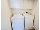 This laundry room features a modern washer and dryer, plus overhead cabinet space for storing essentials at 9050 W Tropicana Ave # 1178, Las Vegas, NV 89147